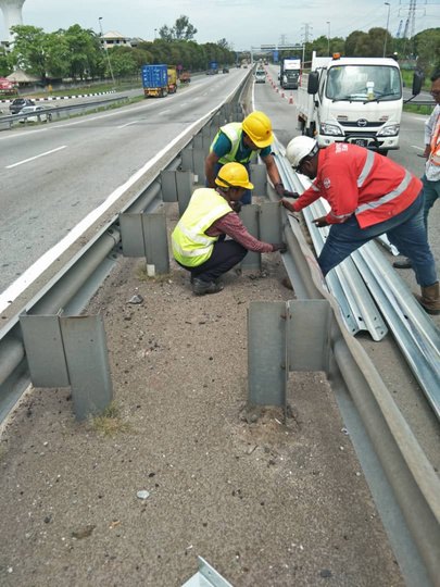 Installing W-beam guardrail on a highway median — Muhibah Konsortium Holdings civil works