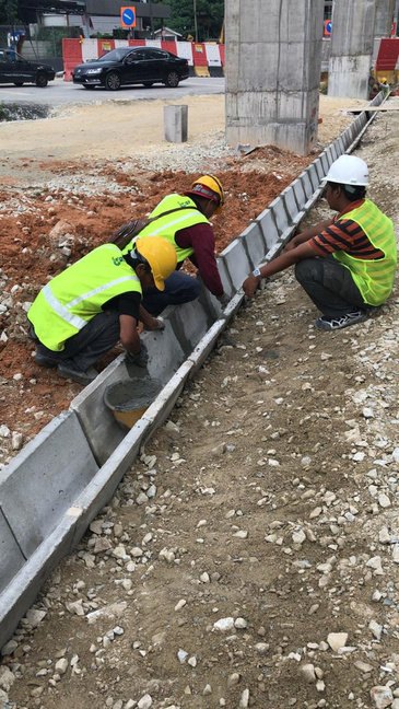 Laying precast roadside drain units — Muhibah Konsortium Holdings civil works